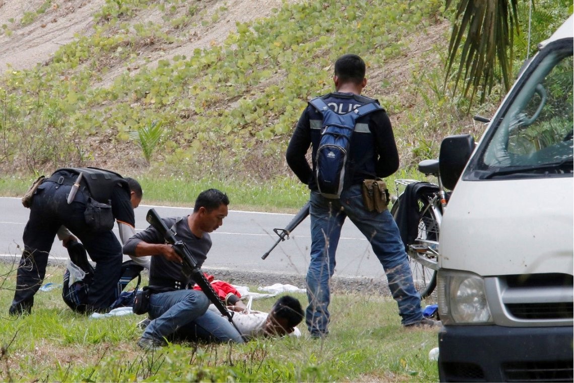 Malaysian police search two detained men near Tanduo village on March 6, 2013